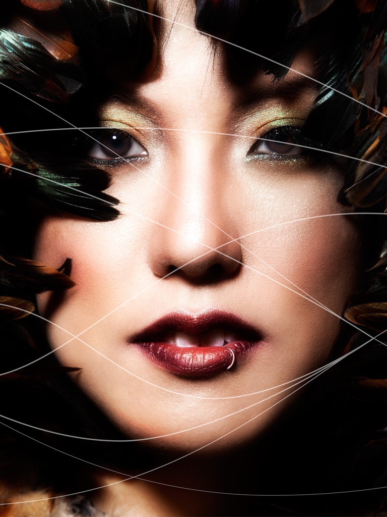 A woman’s face crossed by thin white lines.